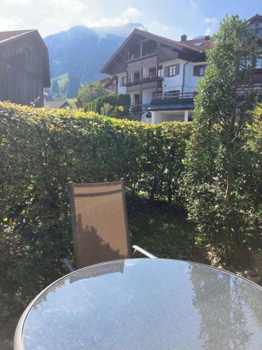 a glass table and a chair sitting at a table at Ferienwohnung Eulennest in Bolsterlang