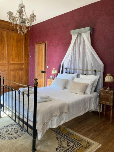 une chambre avec un grand lit à baldaquin dans l'établissement Chateau Gioux, à Saint-Pierre-Bellevue