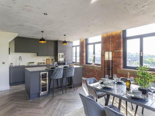 a kitchen and living room with a table and chairs at 5-Bedroom Luxury Duplex Penthouse in Bradford