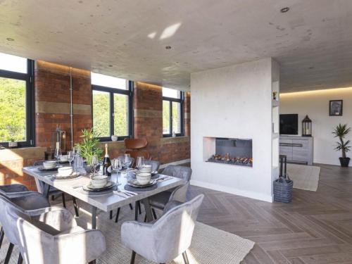 a dining room with a table and chairs and a fireplace at 5-Bedroom Luxury Duplex Penthouse in Bradford