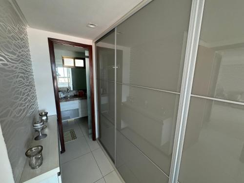 a bathroom with a shower with a glass door at Luxor Tambaú in Tambaú