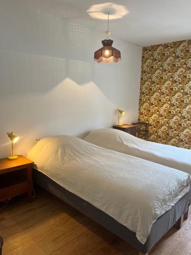 une chambre avec un lit et une lampe sur une table dans l'établissement Domaine Lagarrière, à LʼIsle-Bouzon