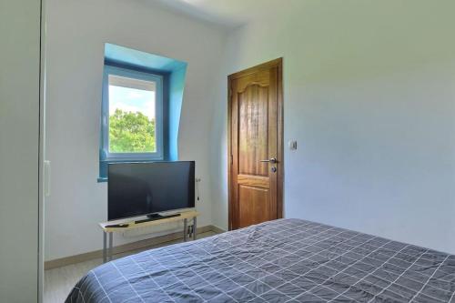 une chambre avec un lit et une télévision à écran plat dans l'établissement Appartement Charmant Très Proche Centre-Ville, Parking Gratuits, MULHOUSE CENTRE, à Mulhouse