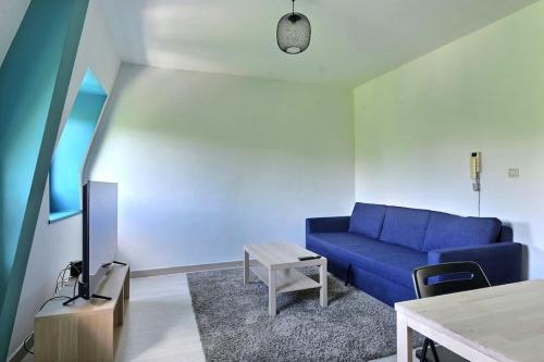 un salon avec un canapé bleu et une table dans l'établissement Appartement Charmant Très Proche Centre-Ville, Parking Gratuits, MULHOUSE CENTRE, à Mulhouse