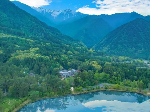an aerial view of a house on a lake in the mountains at Suzuranso in Komagane