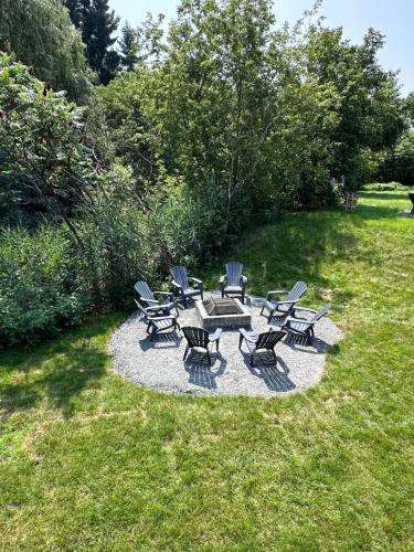 a group of chairs and a picnic table in the grass at L'Escapade - magnifique appartement in Granby
