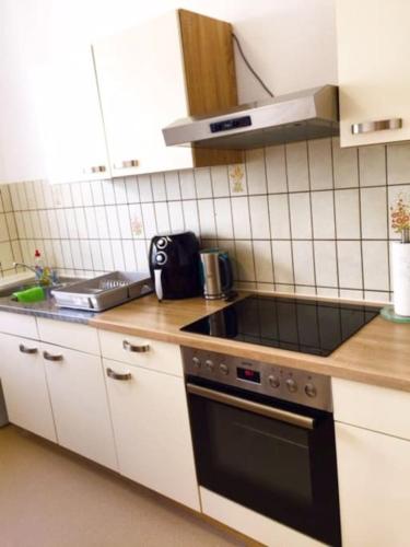 a kitchen with a sink and a stove top oven at Ferienwohnung Dinh in Uhldingen-Mühlhofen