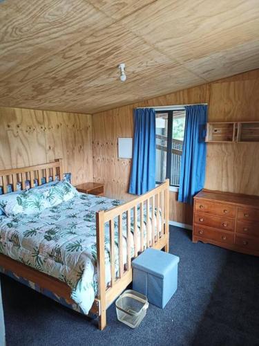 a bedroom with a bed and a wooden ceiling at Valley Views Haast in Haast