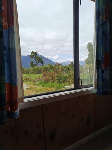 a window in a room with a view of a field at Valley Views Haast in Haast