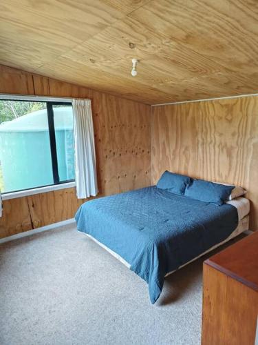 a bedroom with a bed in a room with a window at Valley Views Haast in Haast