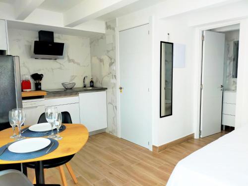 ein Esszimmer mit Tisch und eine Küche in der Unterkunft Moderno Atico Loft en Peñíscola Centro, cerca de la Playa y el Castillo Papa Luna in Peñíscola