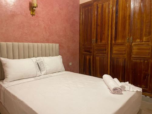 a bed with white sheets and pillows in a bedroom at La ROSE Des SABLE in Sfiani