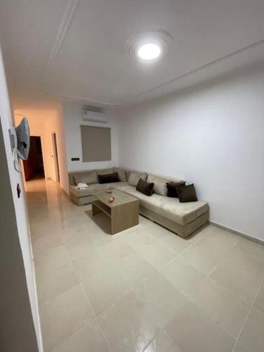 a living room with a couch and a table at Appartement lot al HANAA 3 in Monte ʼArrouit