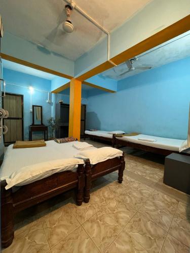 a bedroom with two beds and a blue wall at Casanova by the Sea - Just a walk away to Canacona Beach in Palolem