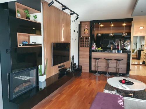 a living room with a bar with a fireplace at Modern Retreat in Skopje
