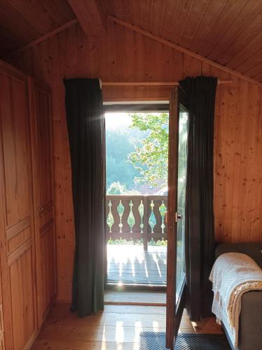 a bedroom with a door open to a balcony at Burgberg Schöllnstein in Iggensbach