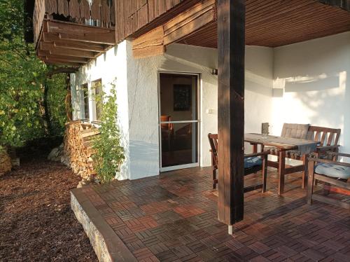 una casa con patio con mesa de madera y sillas en Burgberg Schöllnstein, en Iggensbach