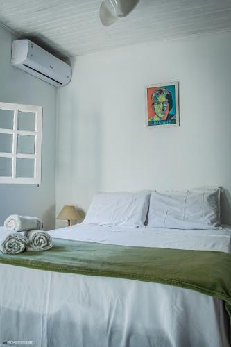 a bedroom with a large bed with a green blanket at Pousada no Sana Donna Leda in Sana