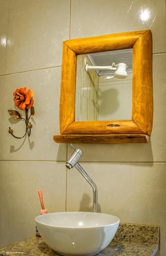 a bathroom sink with a mirror and a white bowl at Pousada no Sana Donna Leda in Sana