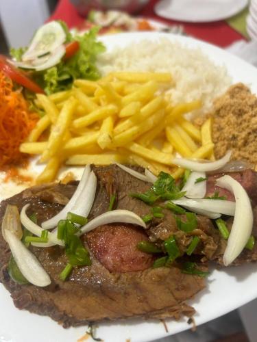 a plate of food with french fries and meat at Pousada no Sana Donna Leda in Sana