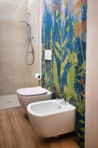 a bathroom with a toilet and a sink and a shower at Sporting Baia Hotel in Giardini Naxos