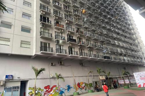 a man standing in front of a building at Hotel O Grand Asia Afrika Apartment By Qr Property in Bandung