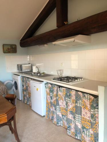 a kitchen with a sink and a stove top oven at Les jardins du presbytère in Beaumes-de-Venise