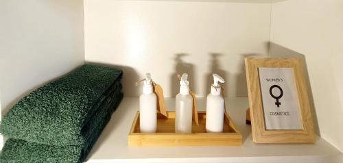 a shelf with two white candles and a picture and a frame at 4star Room 'Kata' - with private bathroom and free air-conditioned summer kitchen in Šarića Struga