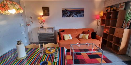 un salon avec un canapé et une table dans l'établissement Vintage chic -central, wifi, mountain view, aux Carroz d'Arâches