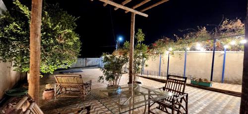 a glass table and chairs on a patio at night at Casa Villa Fortunato Barreiro in Araxá
