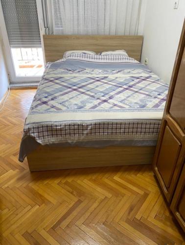 a bed in a bedroom with a wooden floor at GJAKOVA - Cosy Apartment with 3,5 Bedrooms in the Best City Area in Gjakove