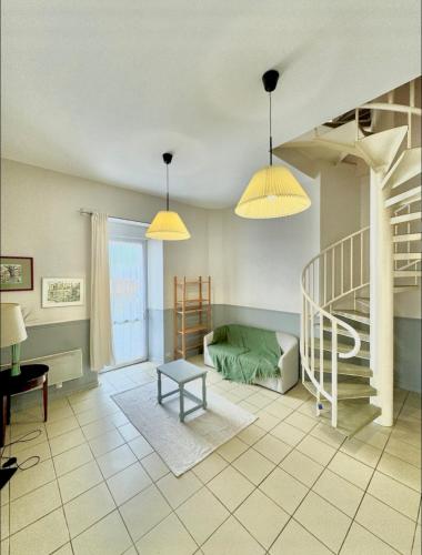 - un salon avec un escalier et deux lumières dans l'établissement Maison au château de Laléard, à Saint-Hilaire-de-Villefranche