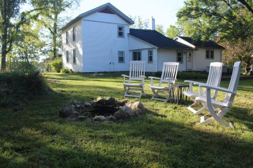 a group of chairs sitting in the grass in front of a house at The Lake Barndominium in Delton