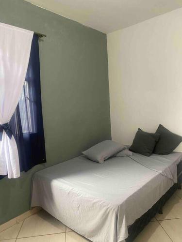 a bed in a room with a window at Casa Nova in Barreiro