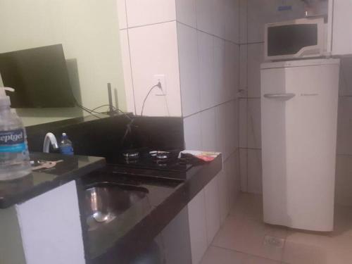 uma pequena cozinha com pia e micro-ondas em Casa Nova em Barreiro