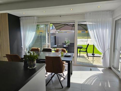 une cuisine et une salle à manger avec une table et des chaises dans l'établissement La Belle Etape, à Sarreguemines