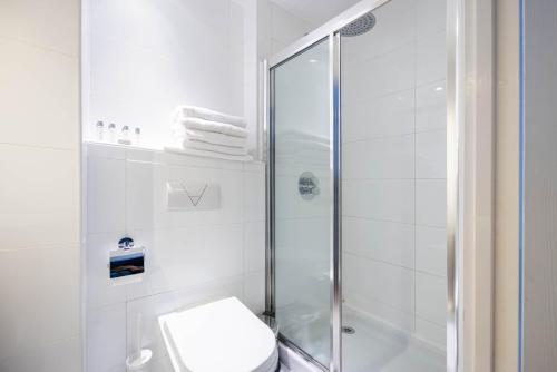 a white bathroom with a shower and a toilet at Cathedral Quarter Hotel - Derby in Derby