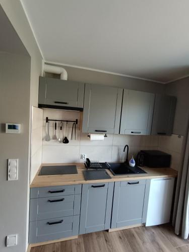 a kitchen with white cabinets and a counter top at Noclegi u Edyty in Zator