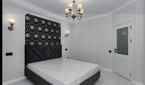 a bedroom with a bed and a chandelier at Airport-Hotel in Chişinău
