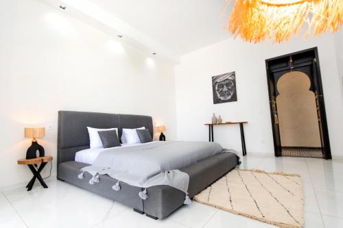 a bedroom with a large bed in a white room at Villatina suite RABAT in El Aggada