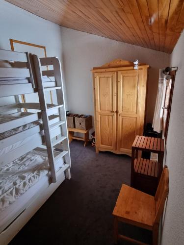 Cette chambre comprend des lits superposés et une armoire en bois. dans l'établissement Duplex 90m2 sur les pistes DU DIMANCHE AU DIMANCHE, à Plagne Villages