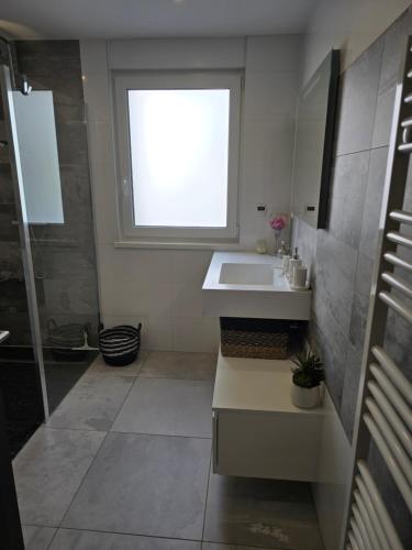 une salle de bain avec un lavabo et une fenêtre dans l'établissement La Belle Etape, à Sarreguemines