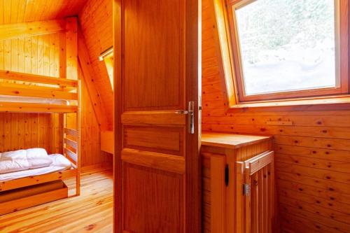 a wooden cabin with a door and a window at Le Chalet Cosy - 2 chambres - MÉNAGE INCLUS in Puyvalador