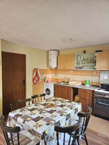 a kitchen with a table and chairs in a kitchen at Villa Altiparmak in Resen