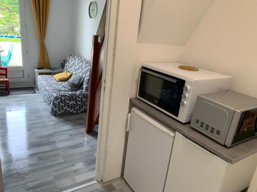 un micro-ondes posé sur un comptoir dans une cuisine dans l'établissement Studio duplex vue mer 100m de la plage, à Saint-Nic