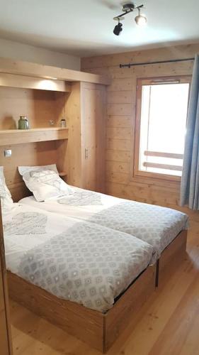 une chambre avec deux lits jumeaux et une fenêtre dans l'établissement Appartement confortable pour 6 personnes, à Champagny-en-Vanoise