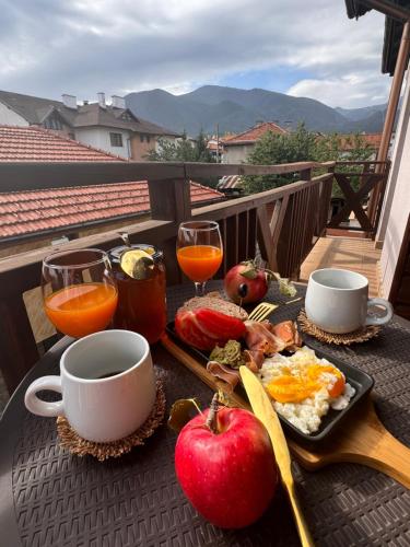 ein Tablett mit Frühstücksspeisen auf einem Tisch auf einem Balkon in der Unterkunft Honey House in Bansko