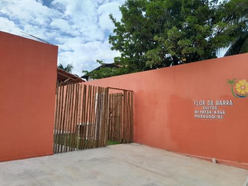 a gate to a building with a fence at Pousada Flor da Barra in Maragogi