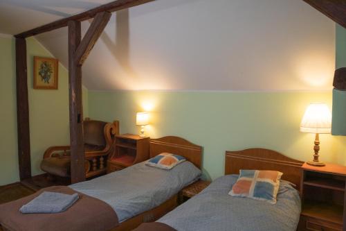 two twin beds in a room with two lamps at Dziki domek in Sierpnica