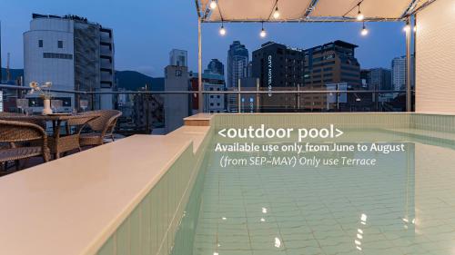 a rooftop bar with a view of the city at Denbasta Central Hotel Seomyeon in Busan
